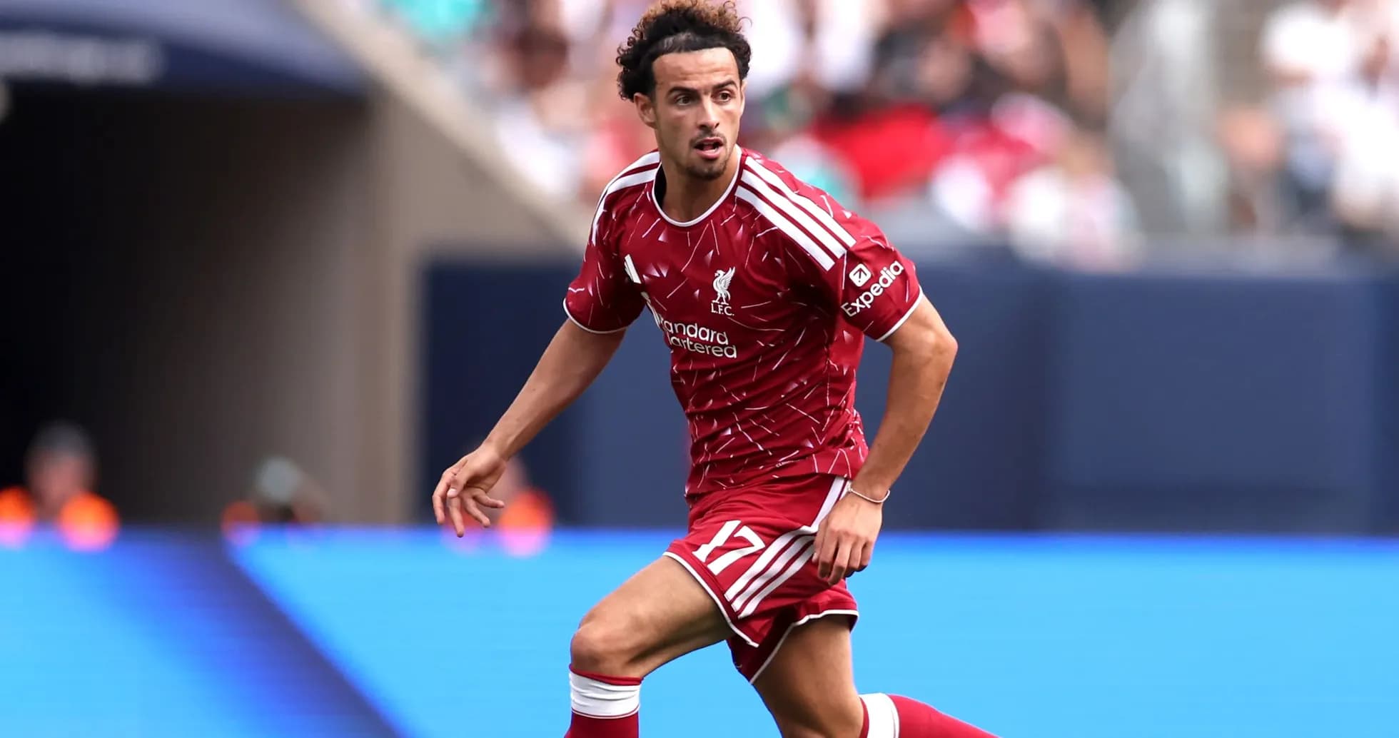Player in red Liverpool kit running on the field Player in red Liverpool kit running on the field