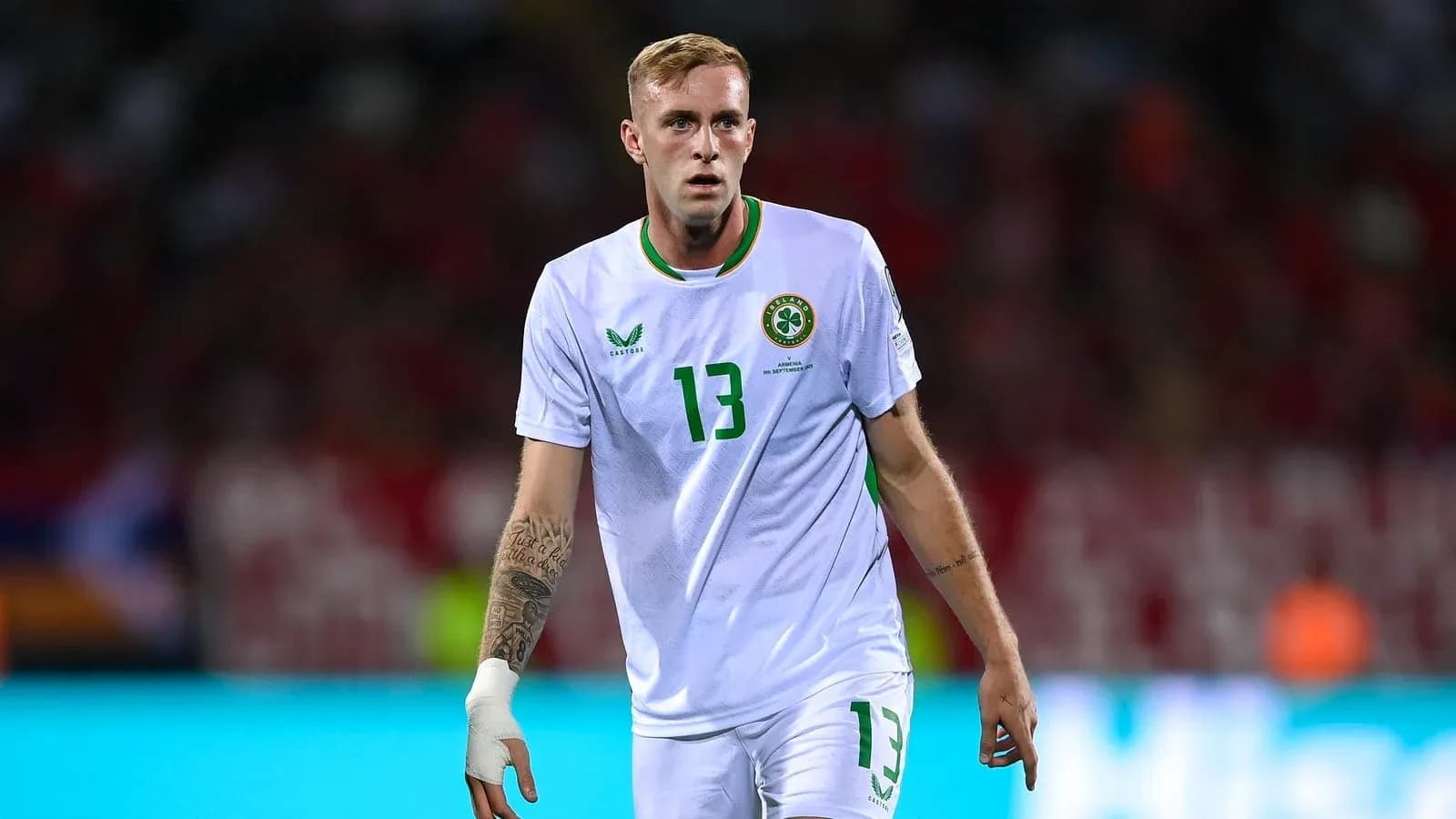 Player in white jersey walking on the pitch Player in white jersey walking on the pitch