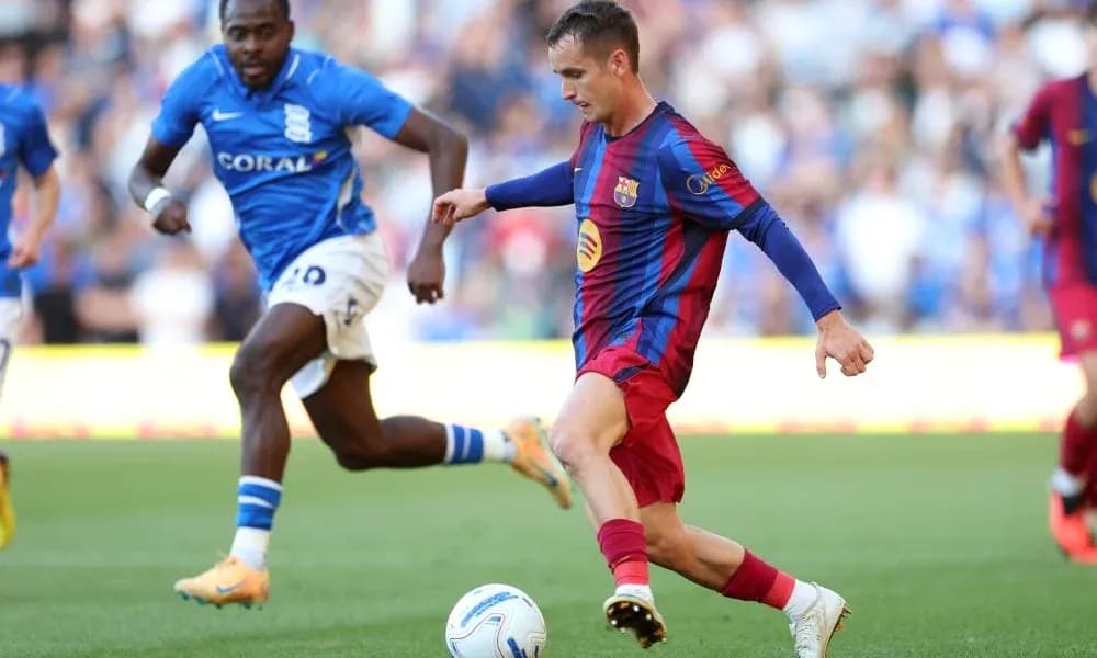 Barcelona player dribbling past Birmingham opponent Barcelona player dribbling past Birmingham opponent
