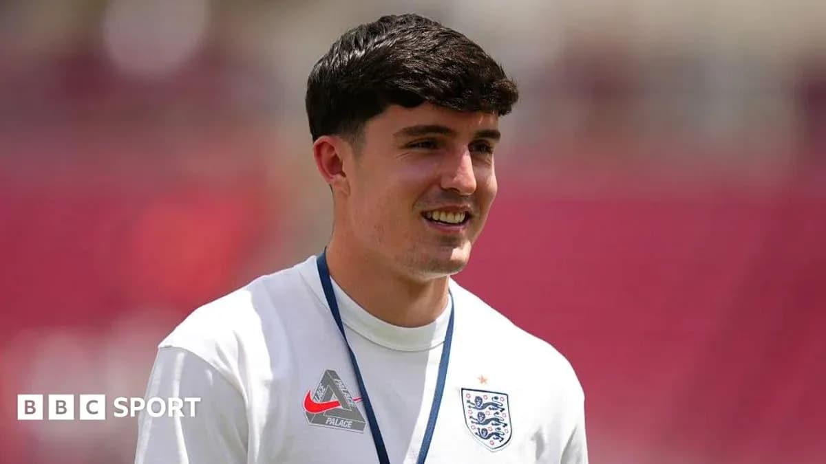 Player in England training kit smiling on pitch Player in England training kit smiling on pitch