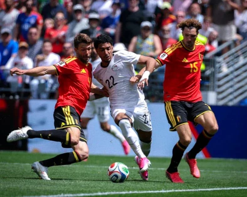 Egyptian player evading two Belgian defenders during match Egyptian player evading two Belgian defenders during match