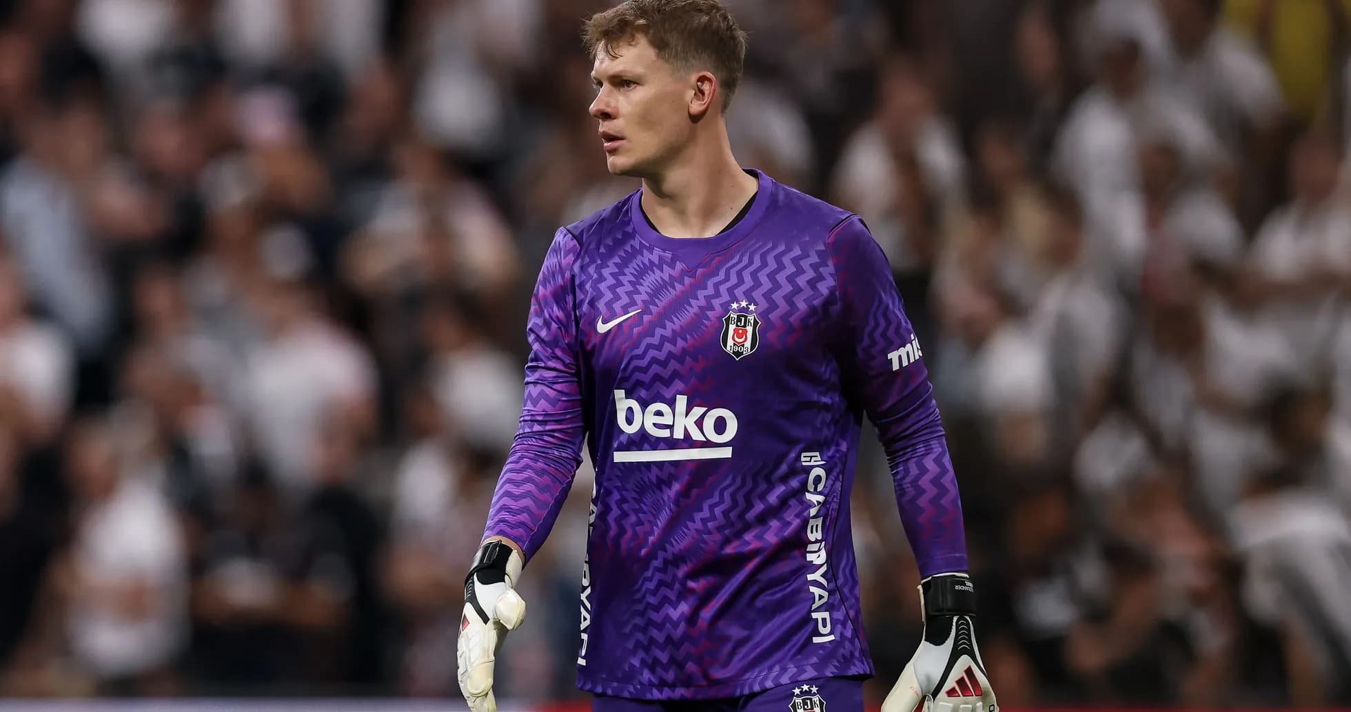 Goalkeeper in purple kit during match action Goalkeeper in purple kit during match action