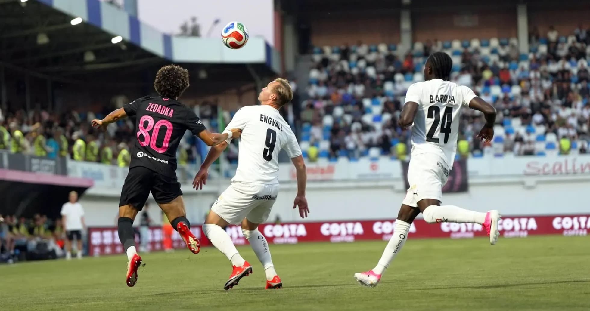 Players competing for the ball in UEFA match Players competing for the ball in UEFA match