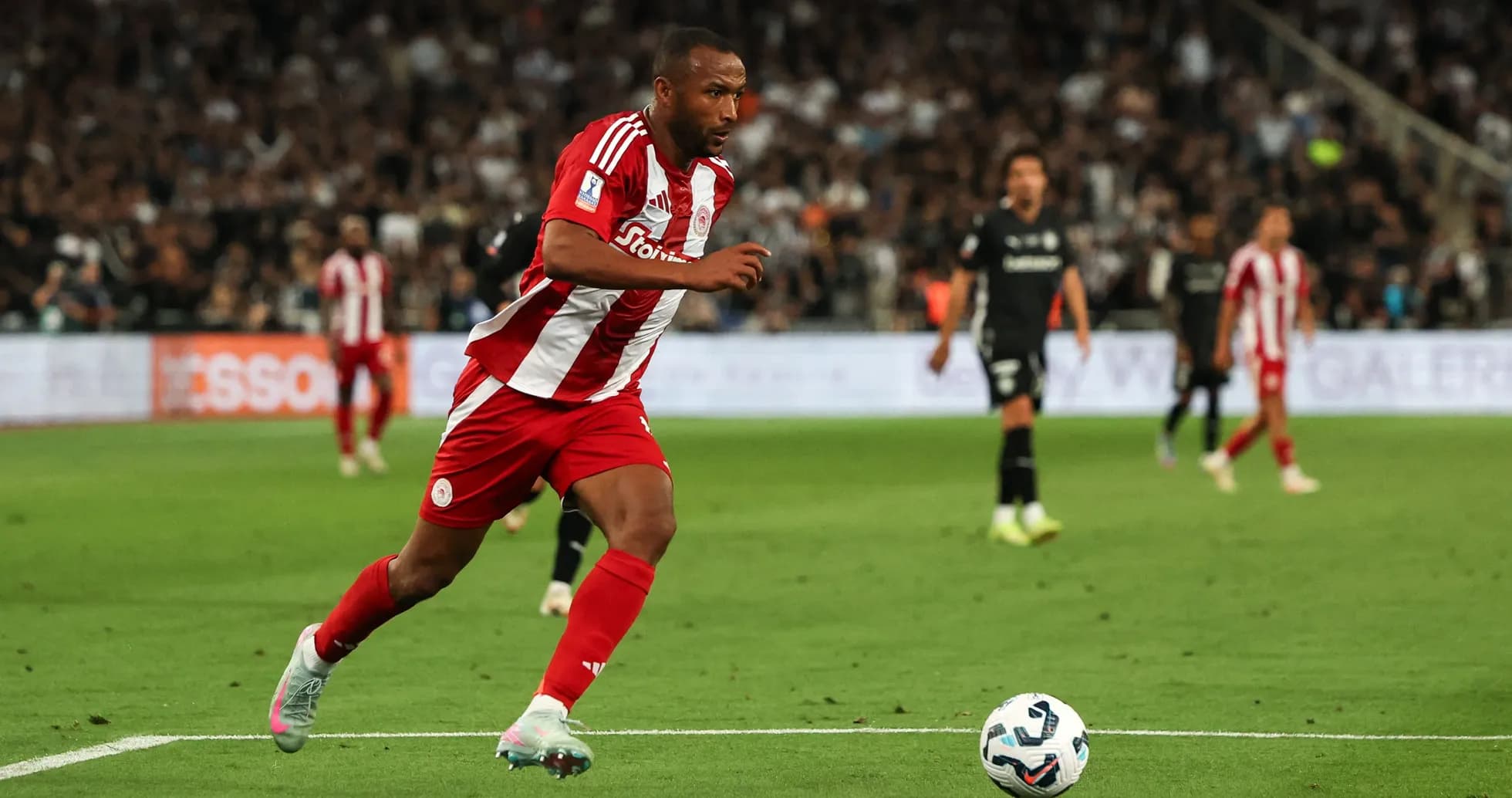 Player in red and white kit running with ball Player in red and white kit running with ball