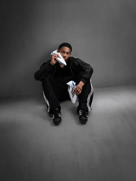 Athlete sitting with soccer shoes in studio setting Athlete sitting with soccer shoes in studio setting