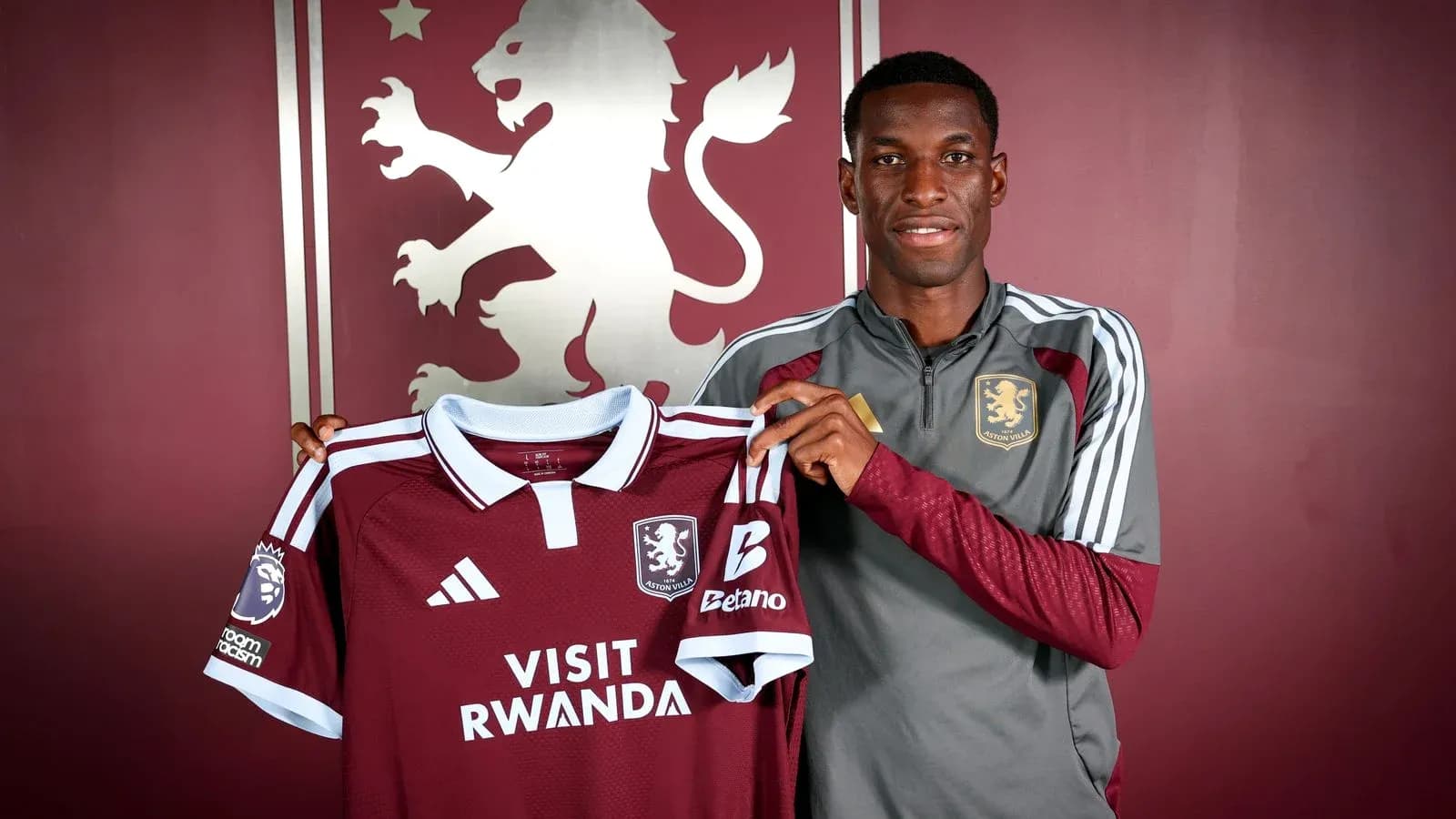 Player holding Aston Villa jersey during signing event Player holding Aston Villa jersey during signing event