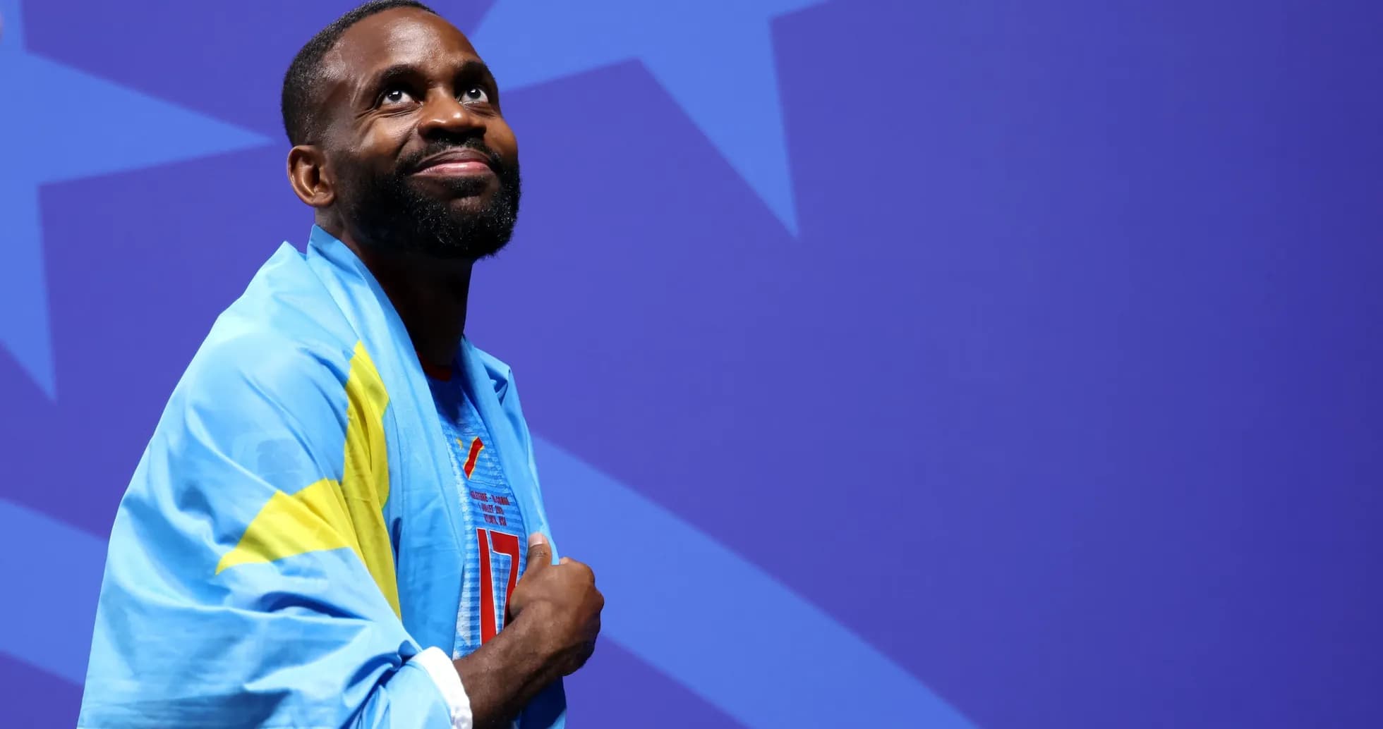 Athlete wearing a blue and yellow flag, looking up Athlete wearing a blue and yellow flag, looking up