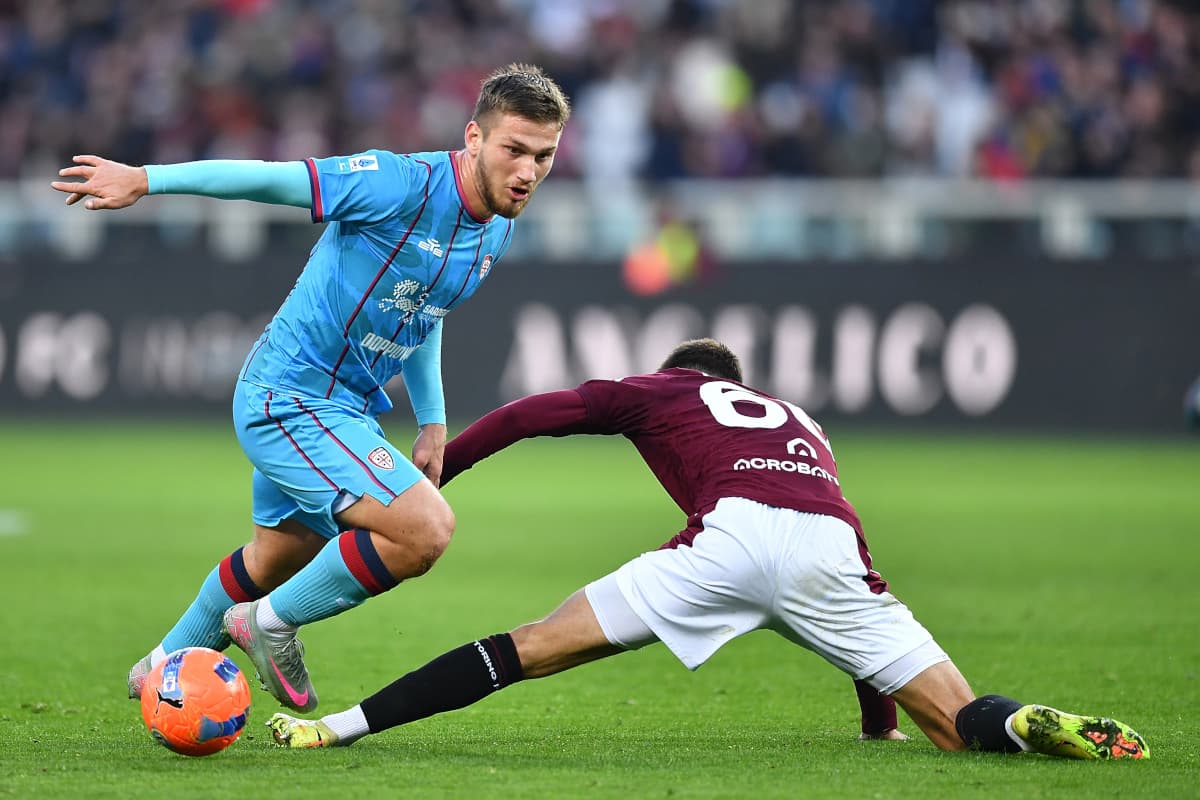 Cagliari player dribbling against Torino defender Cagliari player dribbling against Torino defender