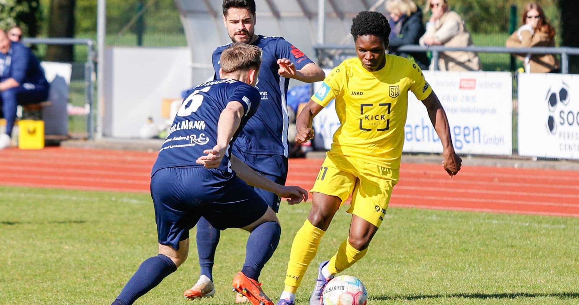 Player in yellow dribbling past opponent in blue Player in yellow dribbling past opponent in blue