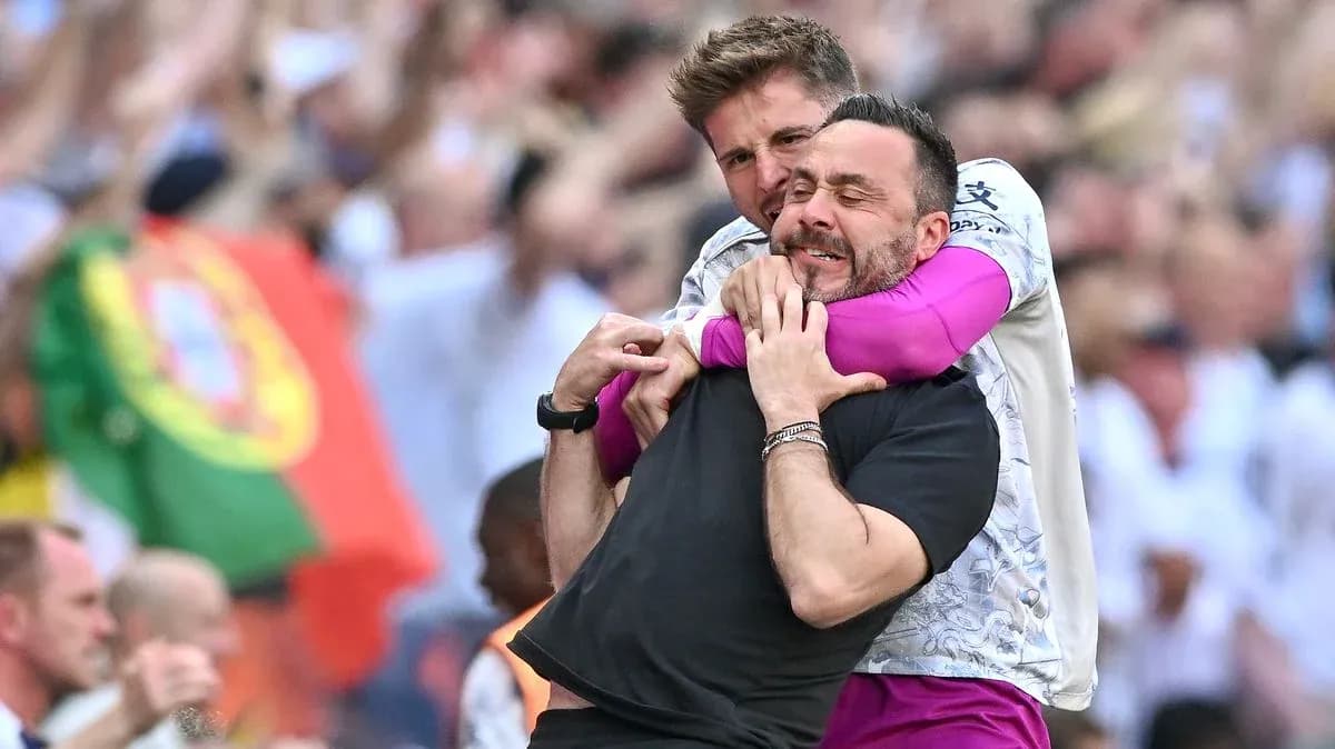Two coaches celebrating a goal on the sidelines Two coaches celebrating a goal on the sidelines