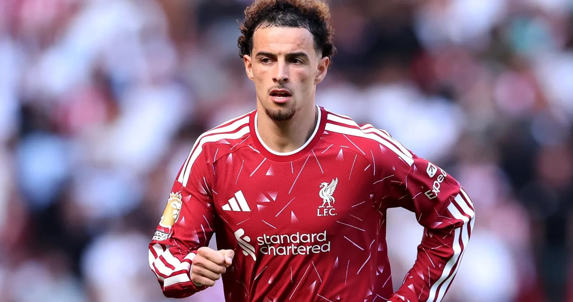 Player in Liverpool FC jersey running on field Player in Liverpool FC jersey running on field