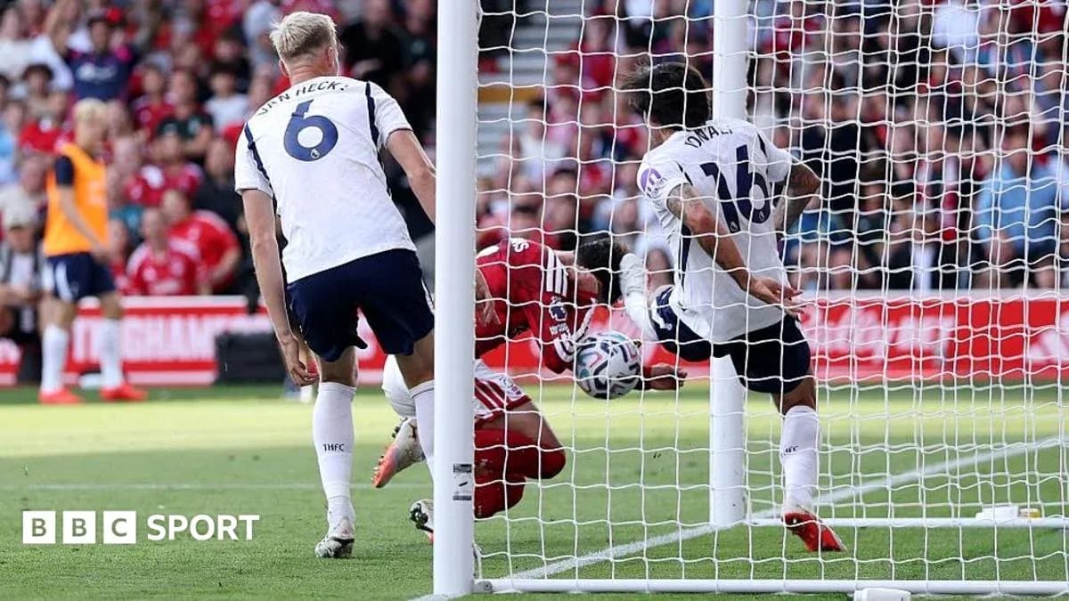 Goalkeeper attempting save as players converge near goal Goalkeeper attempting save as players converge near goal