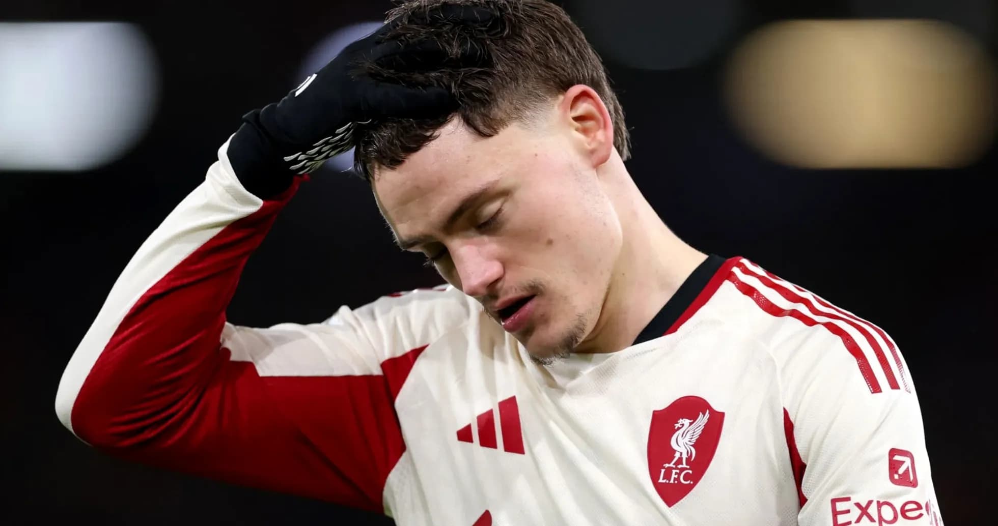 Player in Liverpool kit holding head in disappointment Player in Liverpool kit holding head in disappointment