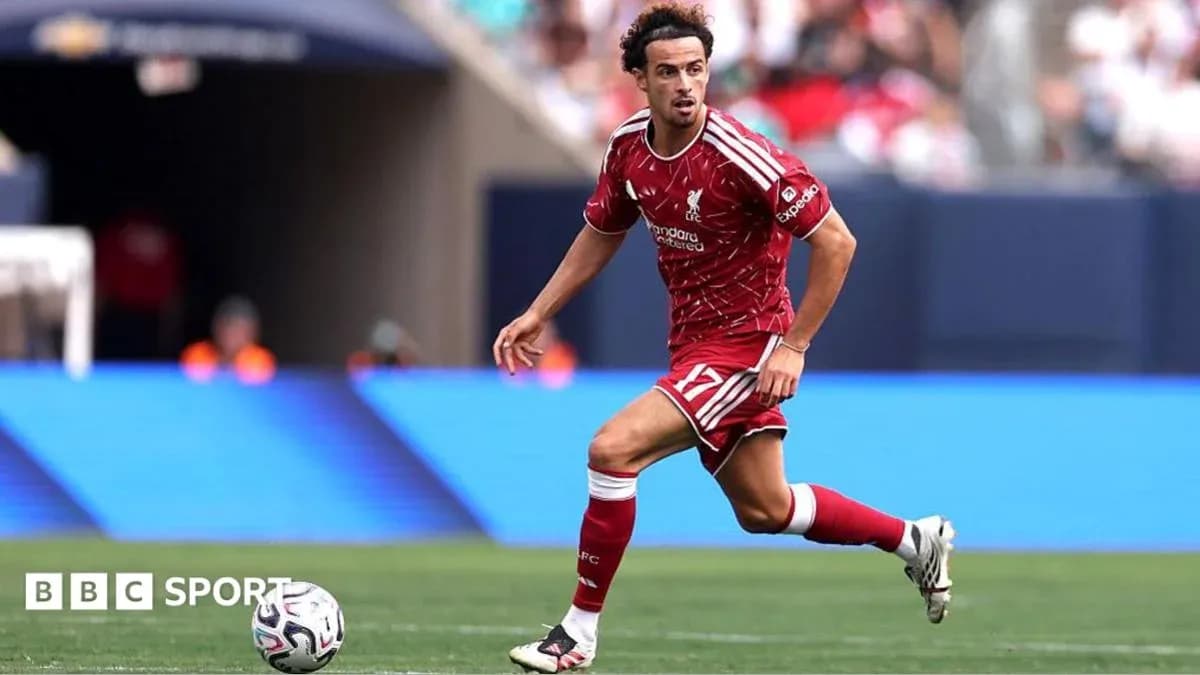 Player in red kit dribbling the ball on field Player in red kit dribbling the ball on field