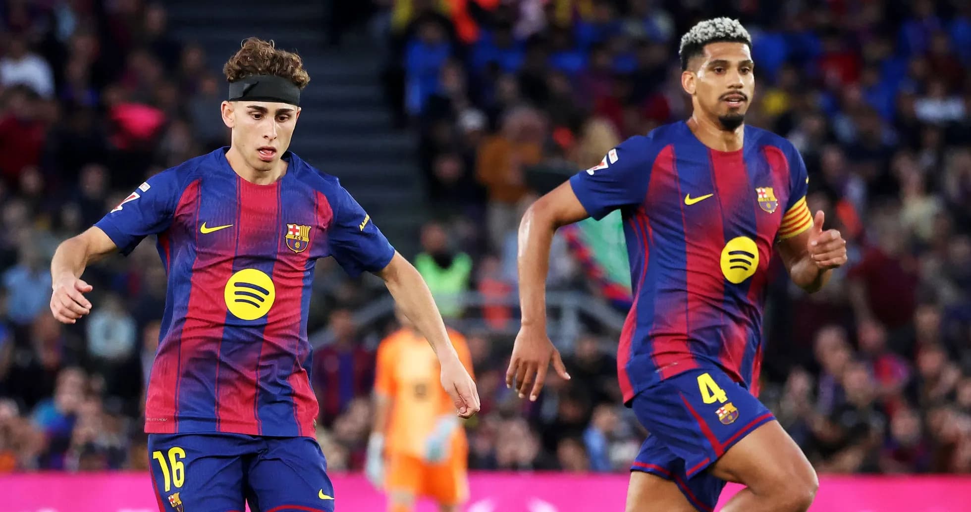 Two FC Barcelona players running on the pitch Two FC Barcelona players running on the pitch