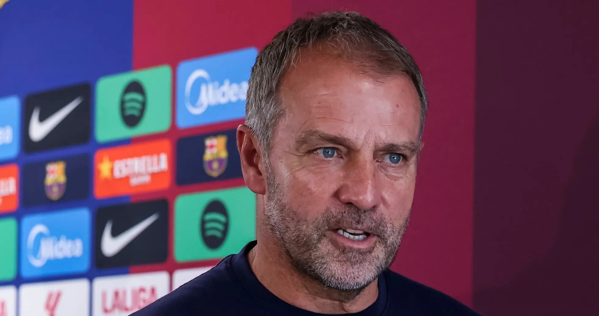 Manager speaking at press conference with club logos behind Manager speaking at press conference with club logos behind