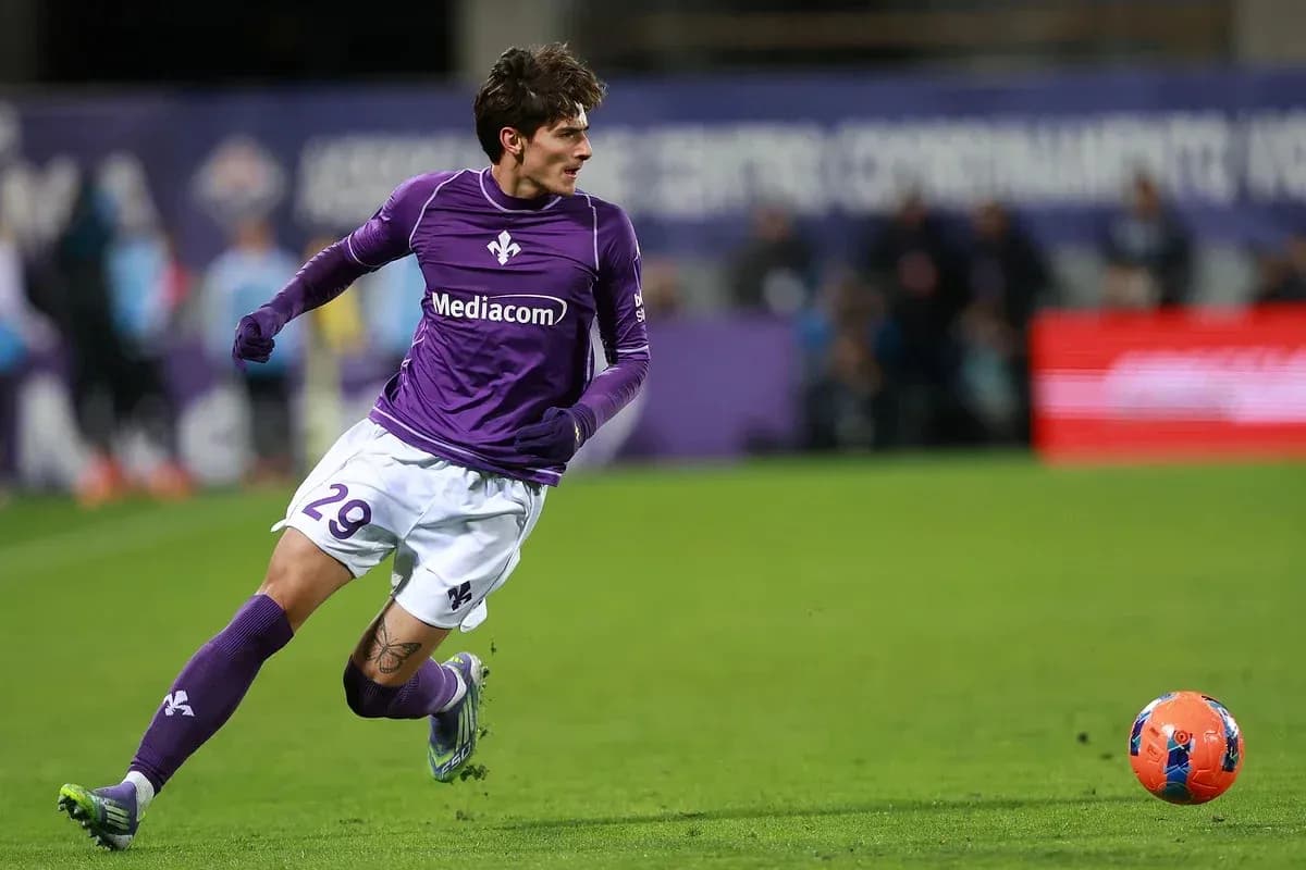 Player in purple jersey running after a soccer ball Player in purple jersey running after a soccer ball