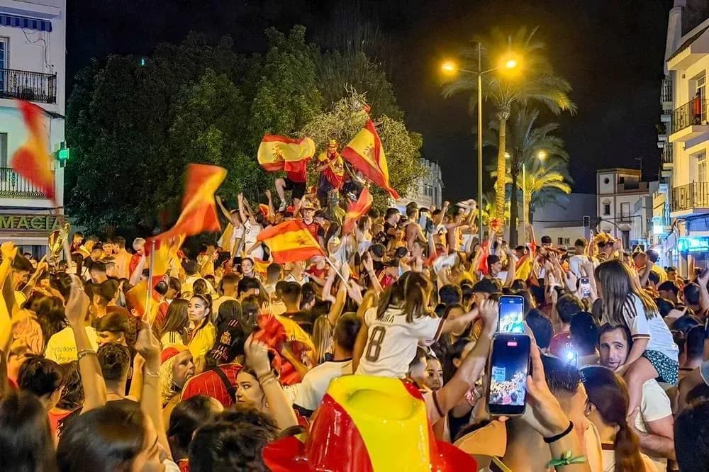 Crowd celebrating at night with Spanish flags Crowd celebrating at night with Spanish flags