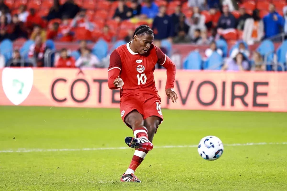 Player in red jersey kicking soccer ball on field Player in red jersey kicking soccer ball on field