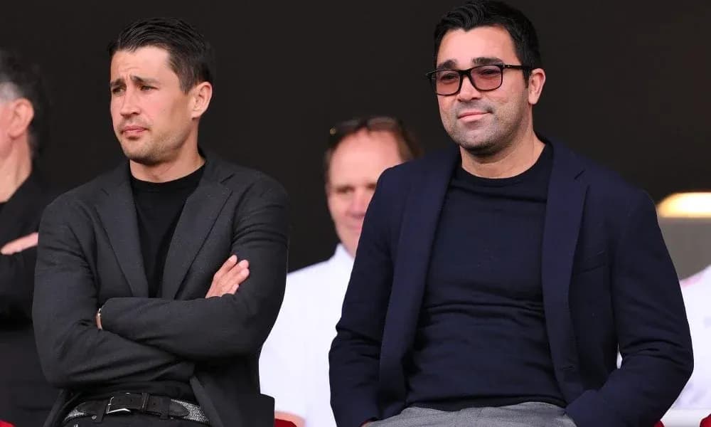 Two men seated in stands during an event Two men seated in stands during an event