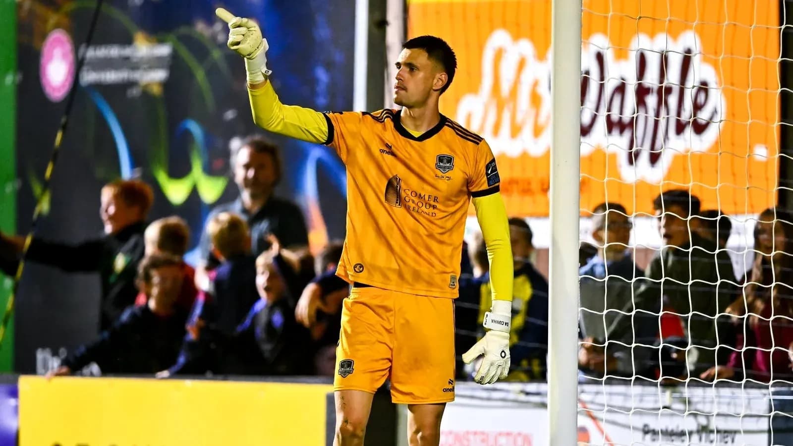 Goalkeeper signaling during a match with fans in background Goalkeeper signaling during a match with fans in background